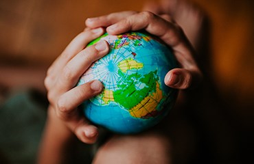 Children's hands holding toy globe