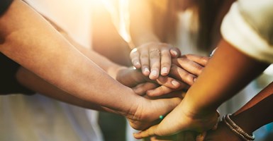 Diverse group of people put their hands together