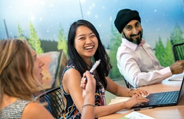 Diverse group of employees sitting around table in a meeting room